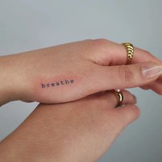 two hands holding each other with the word breathe tattooed on them