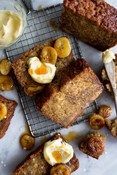 sliced banana bread on a cooling rack with butter and bananas around the edges, along with other baked goods