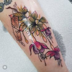 a woman's arm with flowers on it and a name tag in the middle