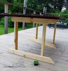 a skateboard is laying on top of a wooden deck in front of a picnic table