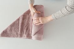 a woman is holding onto a pink towel