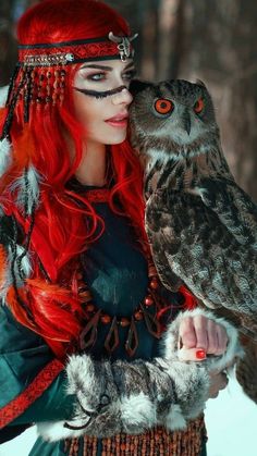 a woman with red hair and an owl on her arm is dressed up in costume