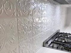 a stove top oven sitting inside of a kitchen next to a white tiled backsplash