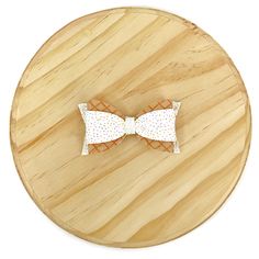 two bow ties sitting on top of a wooden table