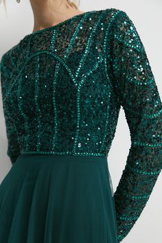 a woman wearing a green dress with sequins on it