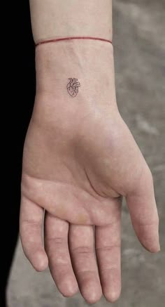 a person's hand with a small tattoo on it