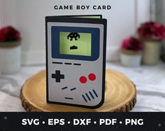 a game boy card sitting on top of a piece of wood next to a potted plant