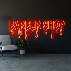 a neon sign that says barber shop on the wall next to a chair and potted plant