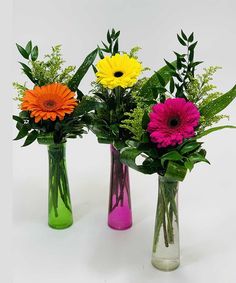 three vases with different colored flowers in them