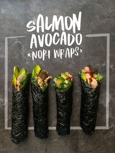 four sushi wrapped in black paper with salmon avocado and nori wraps