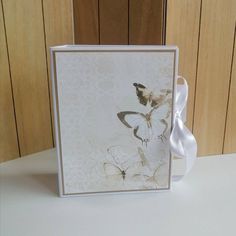 a greeting card with a white ribbon on the front and side, decorated with butterflies