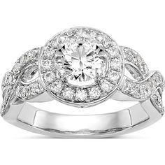 a white gold ring with three diamonds on the band and an oval center surrounded by smaller round