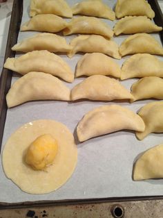 some dumplings and an egg are on a baking sheet ready to go into the oven