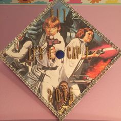 a star wars themed graduation cap hanging on the wall