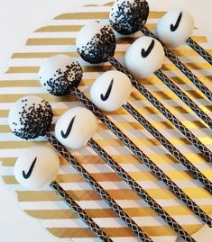 some black and white balls are sitting on top of straws with the word nike painted on them