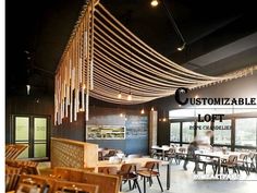 an empty restaurant with tables and chairs in front of large windows that have string lights hanging from the ceiling