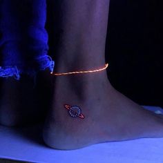 a close up of a person's foot with a beaded bracelet on it