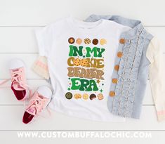 a t - shirt with the words on my cookie decor era next to some shoes