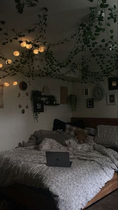 a laptop computer sitting on top of a bed in a room filled with plants and lights