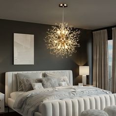 a bedroom with a large bed and chandelier hanging from the ceiling