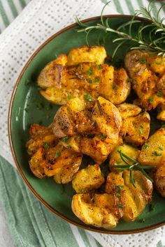 a green plate topped with potatoes and herbs