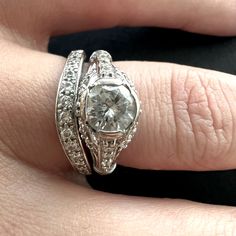 a woman's hand with a diamond ring on top of her finger and an engagement band