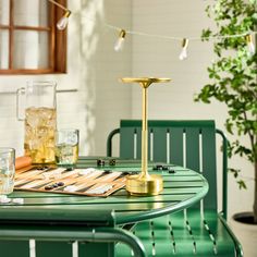 a green table with two chairs and a gold candle holder