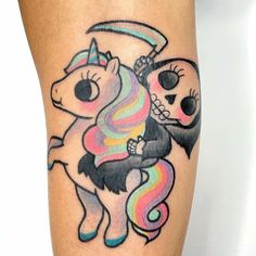 a colorful tattoo on the leg of a person with a unicorn and skull in it