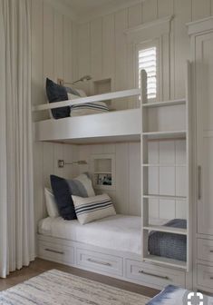 a white bunk bed sitting next to a window