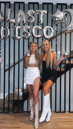 two women posing for a photo in front of a wall with the words blast disco on it