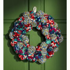 a green door with a wreath hanging on it's side and the bottom part of the door painted red, white, and blue