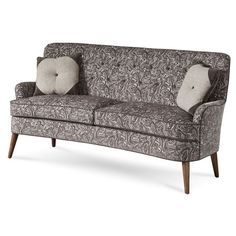 a couch with two pillows on top of it and a wooden frame around the arm