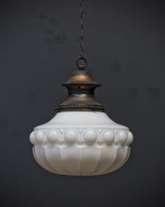 a white glass light hanging from a chain