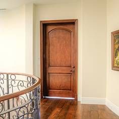 an entryway with a wooden door and metal railing