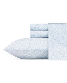 the sheets and pillow cases are made up of blue floral print, with white trimmings