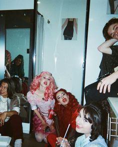 the group of people are all dressed up and posing for a photo in the bathroom