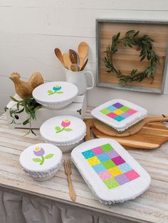 the table is covered with different types of quilts and other crafting supplies on it