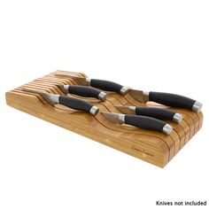 four knives sitting on top of a wooden cutting board with black handles and silver tips