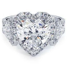 a heart shaped diamond ring with diamonds surrounding it