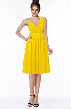 a woman in a yellow dress posing for the camera with her hands on her hips