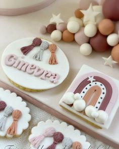 two decorated cookies sitting on top of a table next to some balloons and other decorations