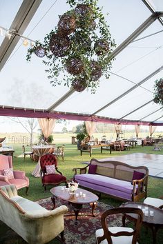 an outdoor tent with couches, chairs and tables