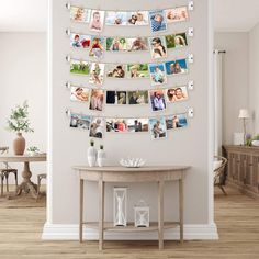 a table with pictures hanging on it in front of a white wall and wooden floor