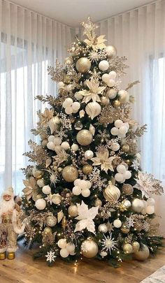 a decorated christmas tree with white and silver ornaments