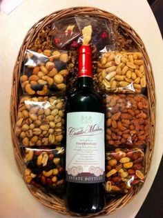 a bottle of wine and nuts in a wicker basket