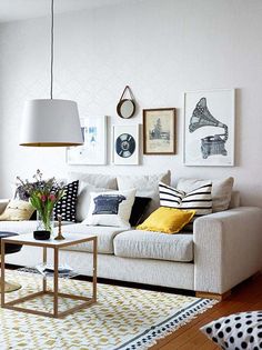 a living room filled with lots of furniture and pictures on the wall above it's coffee table