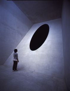 a person standing in front of a large black object