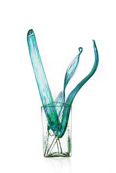 a glass vase filled with blue and green swirly material on top of a white surface