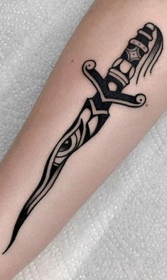 a black and white tattoo on the leg of a person with a knife in it