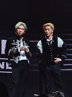 two young men standing next to each other on stage